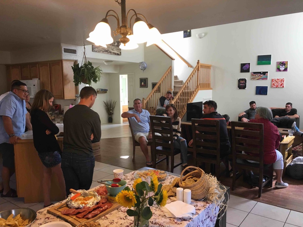 Family members and patients gather together in a living room.