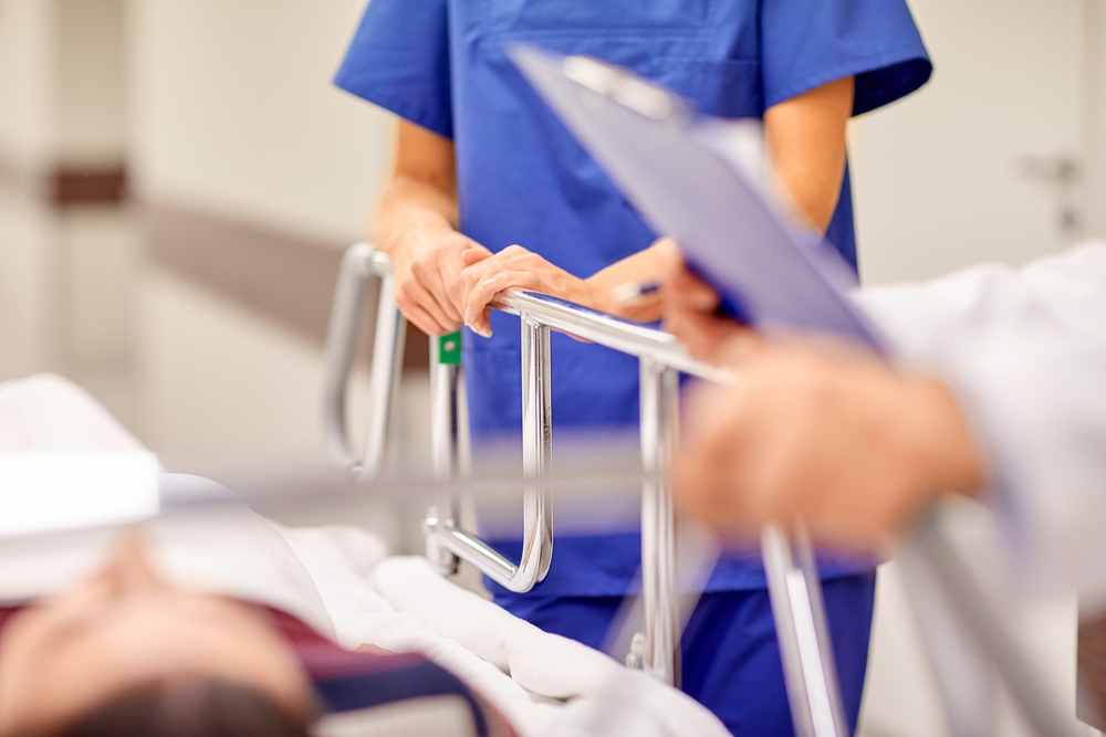 nurse and doctor standing beside a gurney in a hospital.