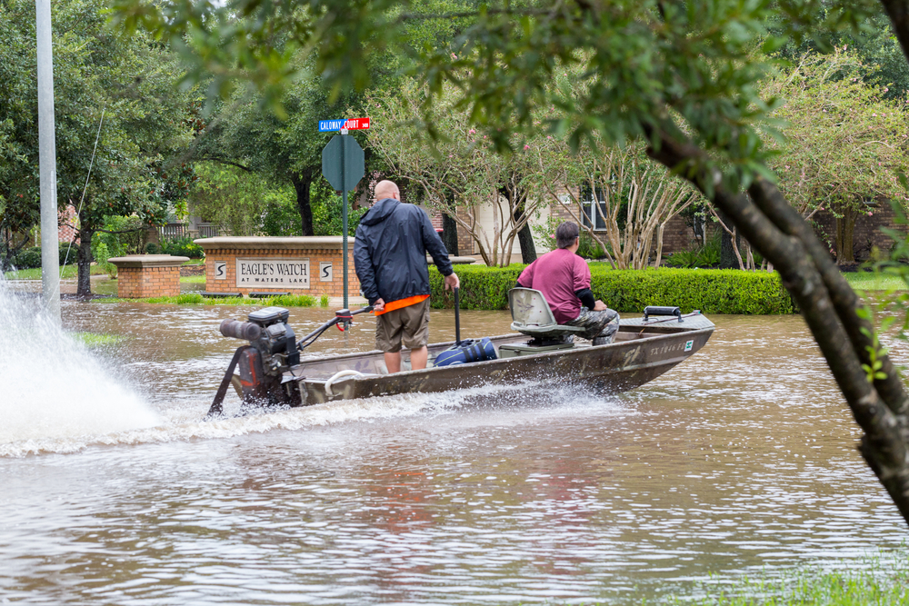 Volunteers from Austin ride a boat in the flooded street,