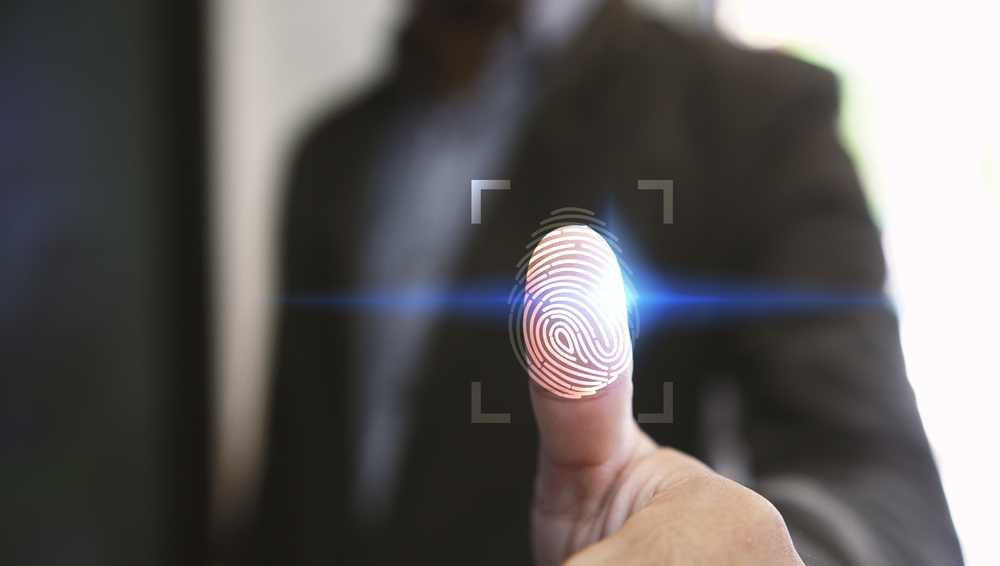 Man holding his thumb up to a simulation of a fingerprint scanner