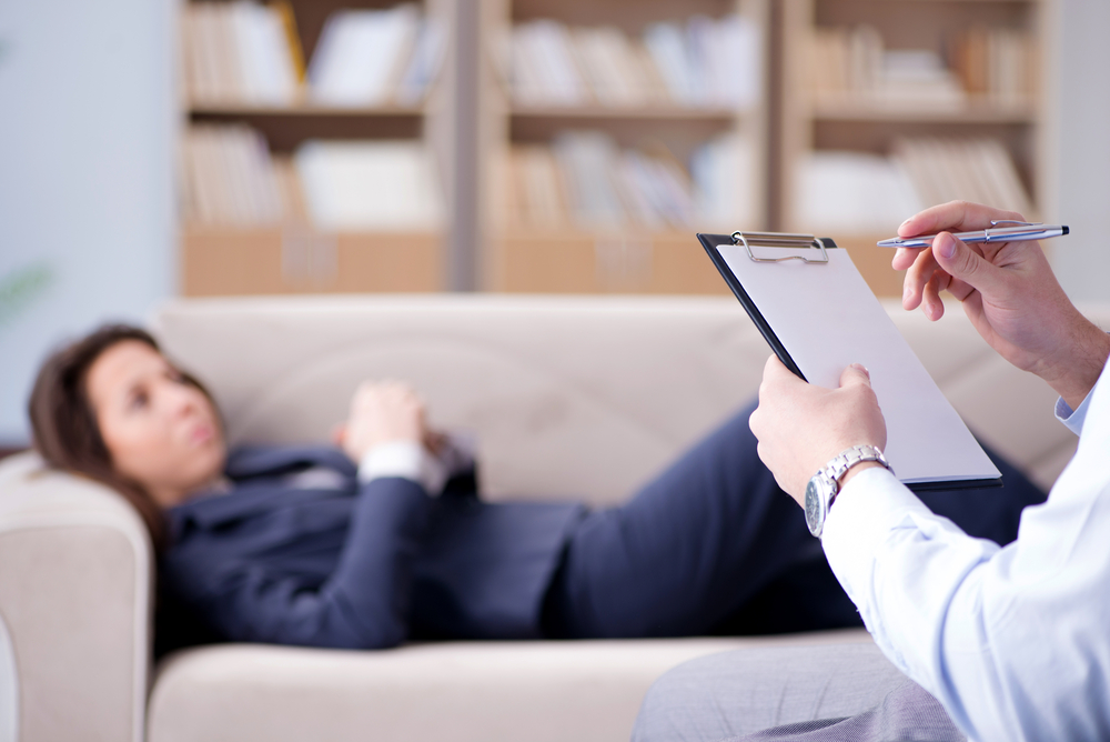 a patient lying in a sofa during a visit with a psychologist.