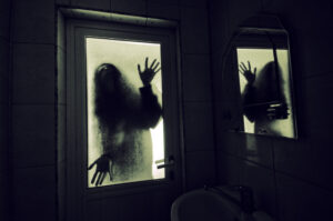 Scary hands and silhouette pushing against a window