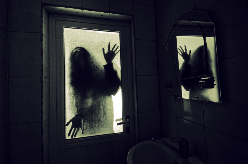 Scary hands and silhouette pushing against a window