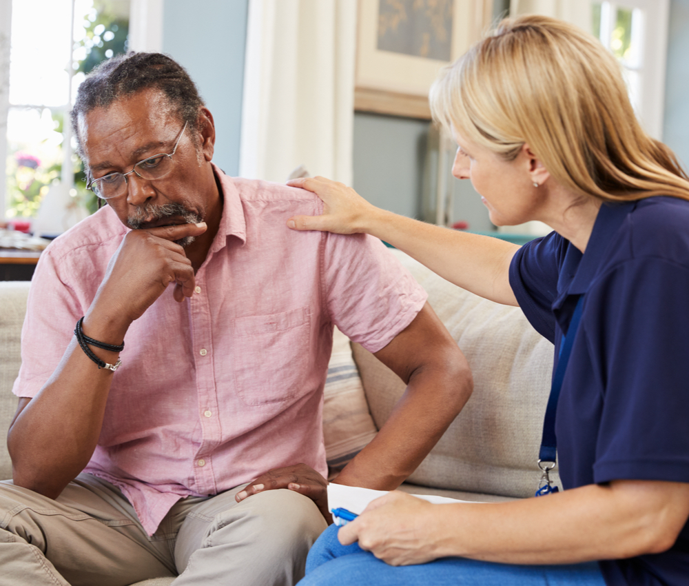 a distressed male patient being comforted by a healthcare professional