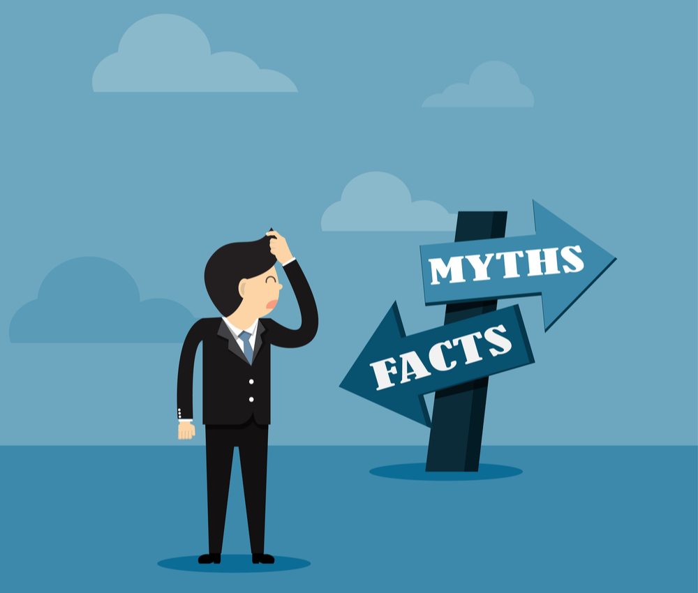 a cartoon businessman looking at directional sign of facts versus myths