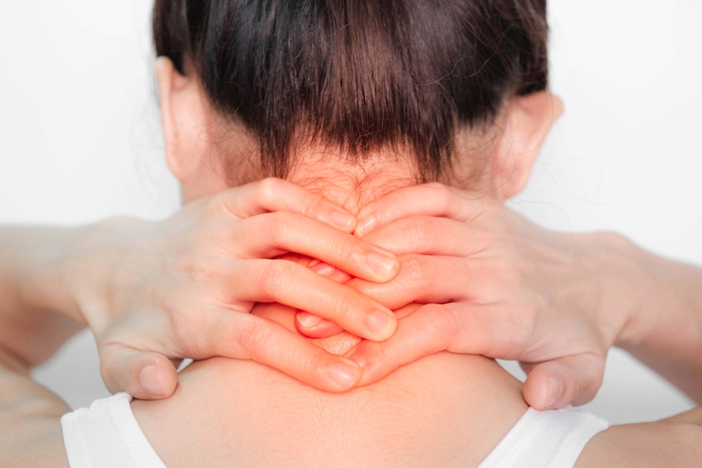woman holding nape of her neck in pain