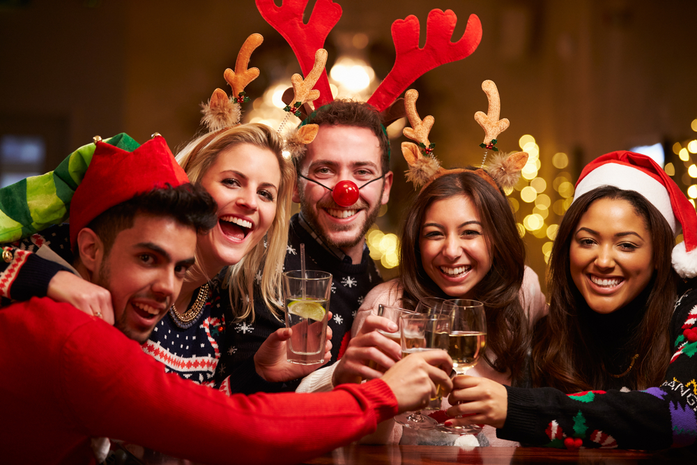 friends toasting their wine glasses at Christmas-themed party