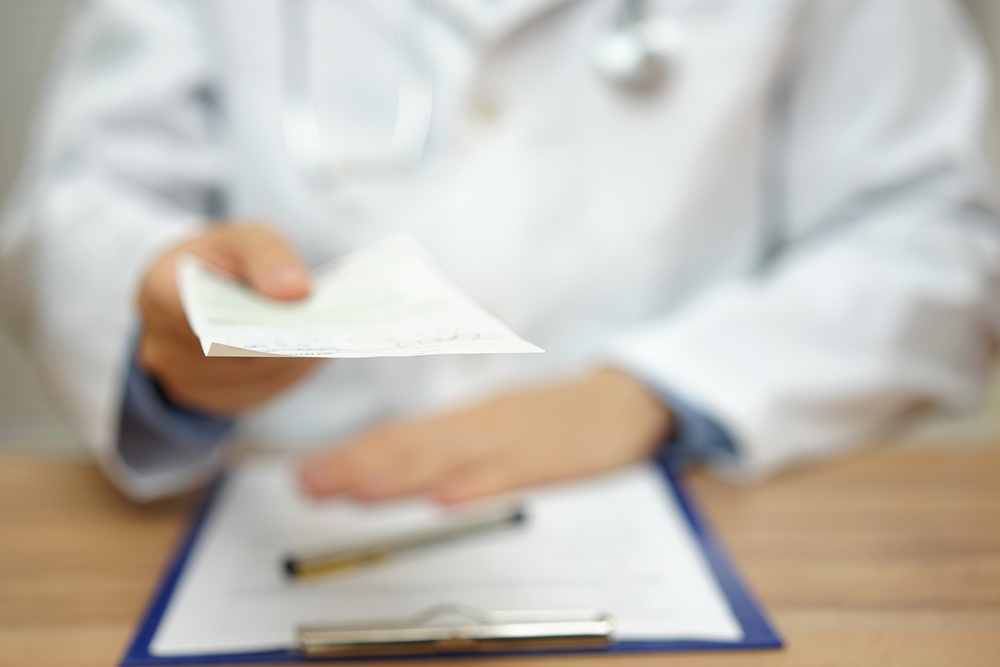 doctor handing prescription out