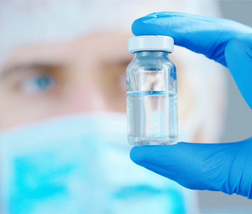 A scientist in laboratory holding a liquid vaccine