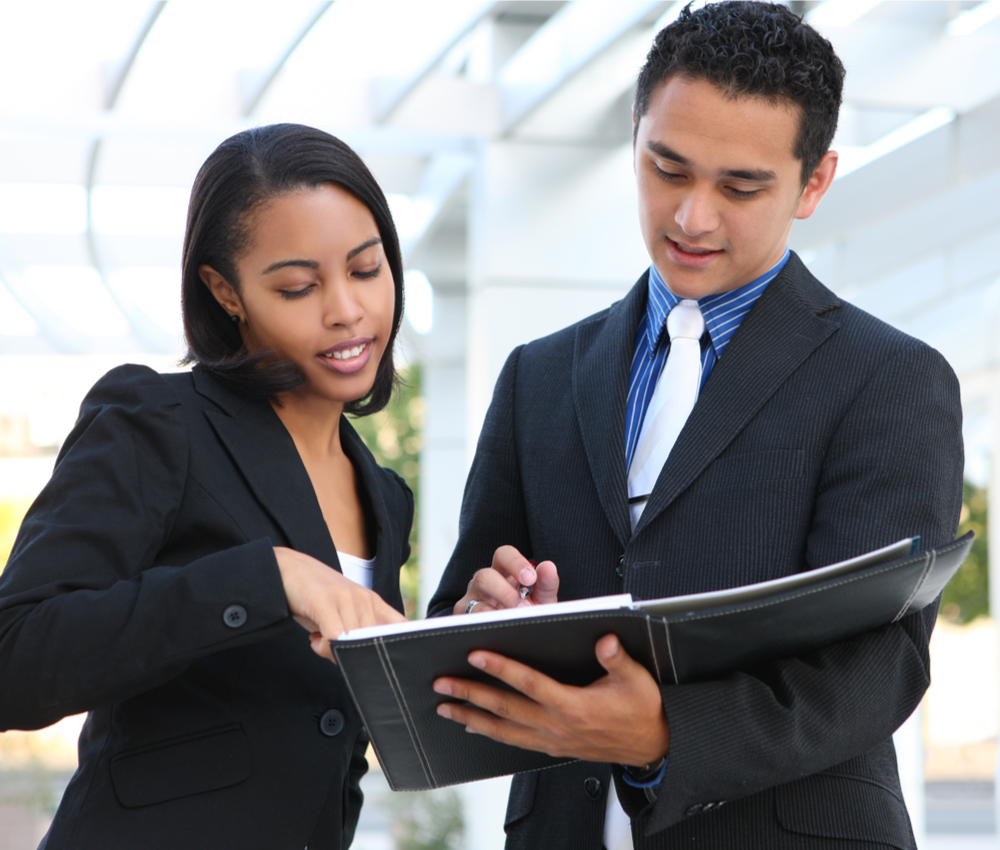 a businesswoman and a businessman looking over paperwork