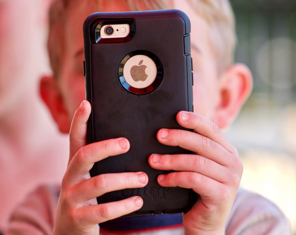 young boy using an iPhone