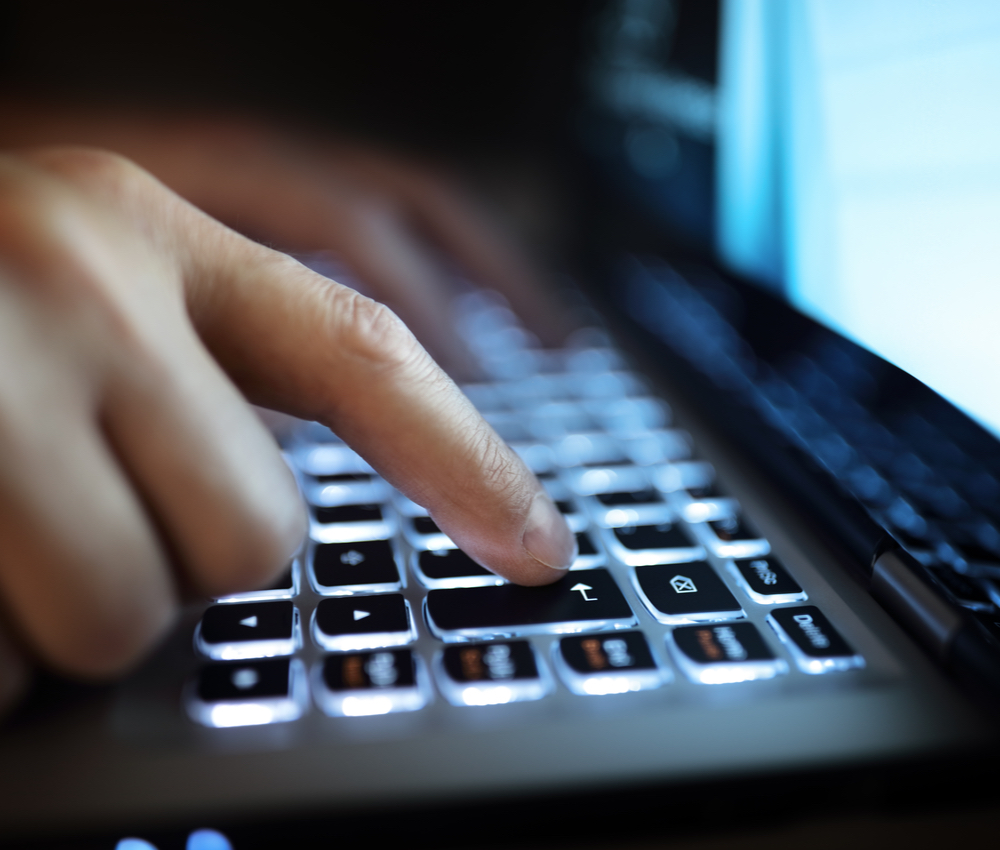 man using laptop computer in the dark