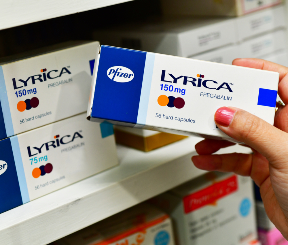 Pharmacist holding a medicine Lyrica box for treatment neuropathic pain in pharmacy drugstore.