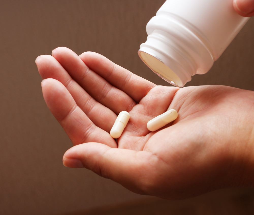 person pouring pills into hand