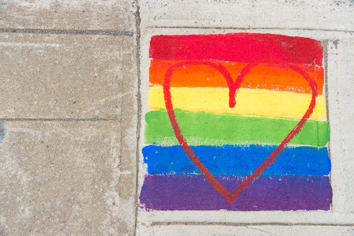 A rainblow flag and heart painted on a sidewalk