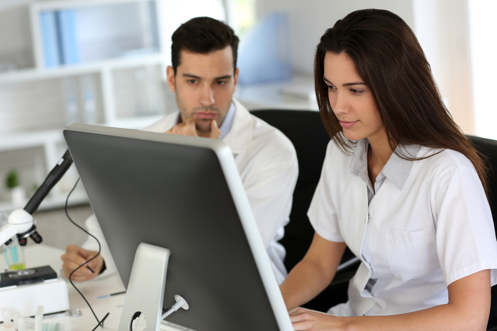 medical professionals sitting in front of a computer in an office