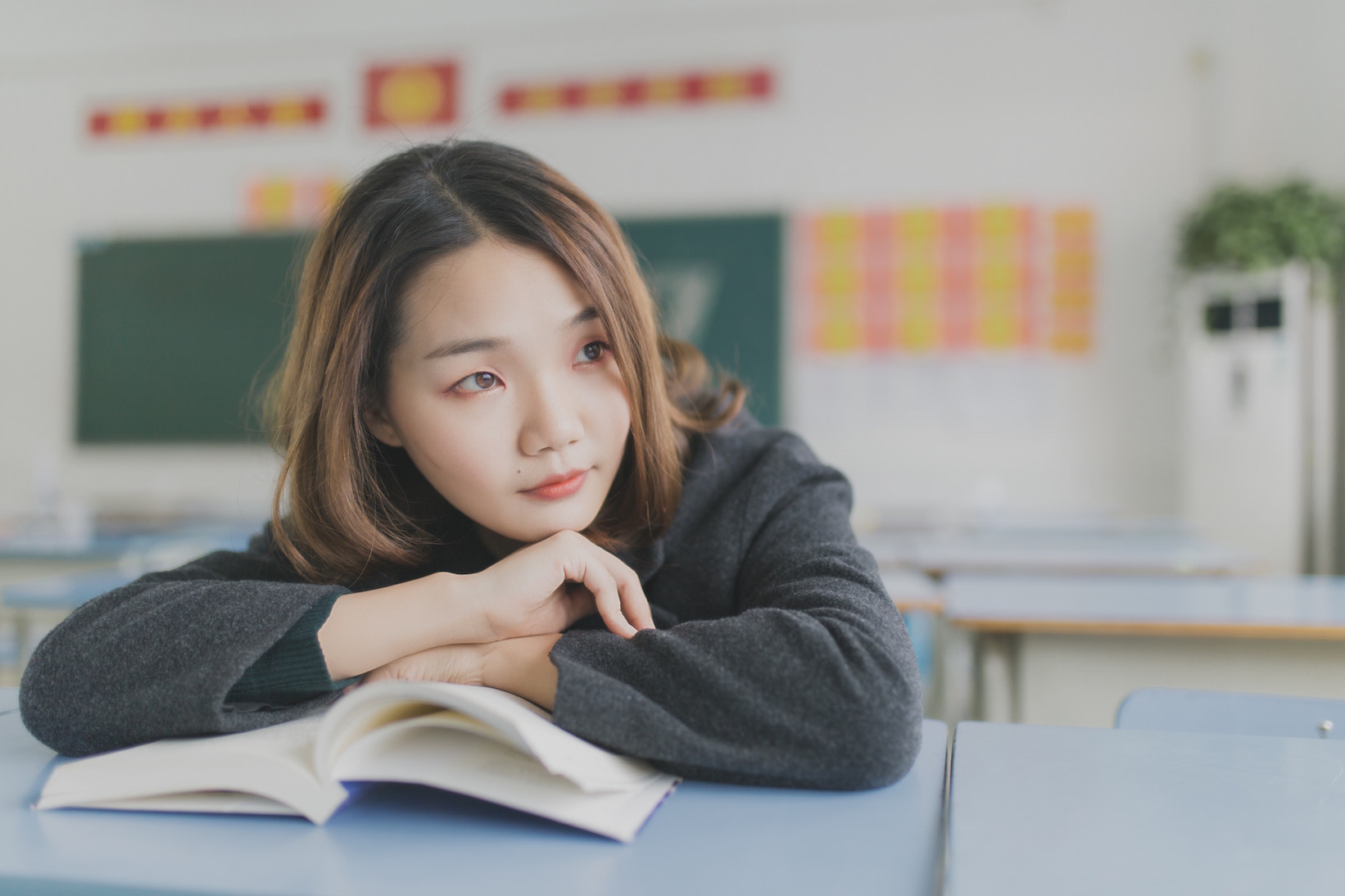 A woman leaning on an open book.