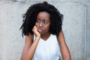 Woman looking to the side, chin on hand.
