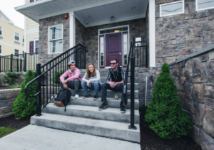 Young people relaxing on the front steps of SOBA