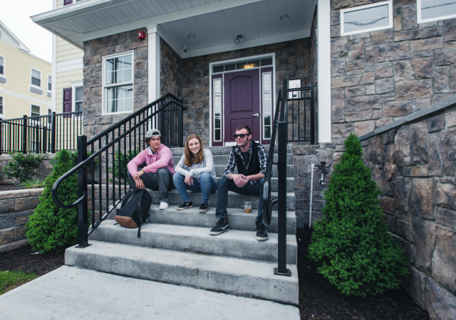 Young people relaxing on the front steps of SOBA