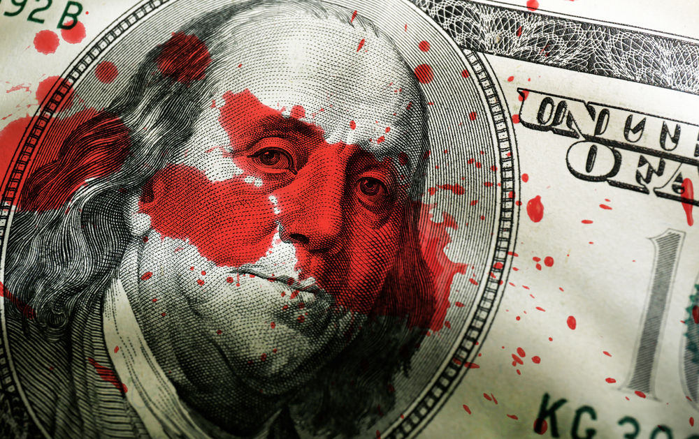 close-up of hundred dollar bill with blood spatter