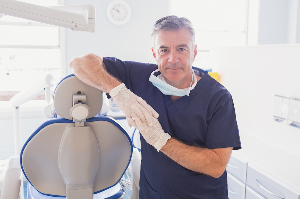 dentist leaning against a dental chair