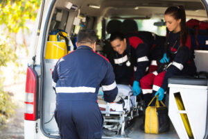 EMT team prepping a stretcher in the back of an ambulance