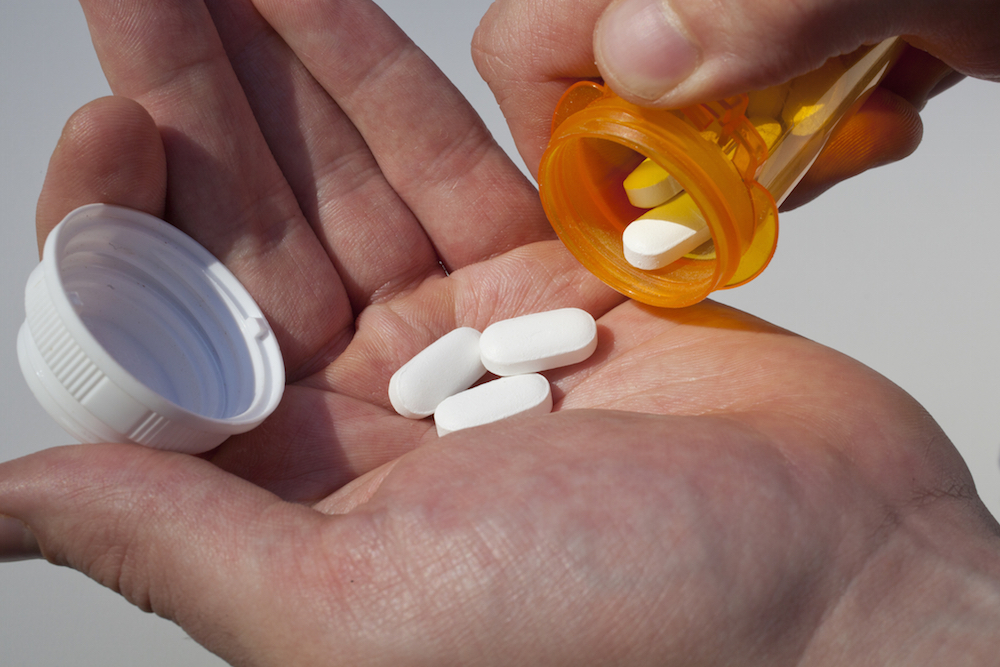 person pouring pills into their hand