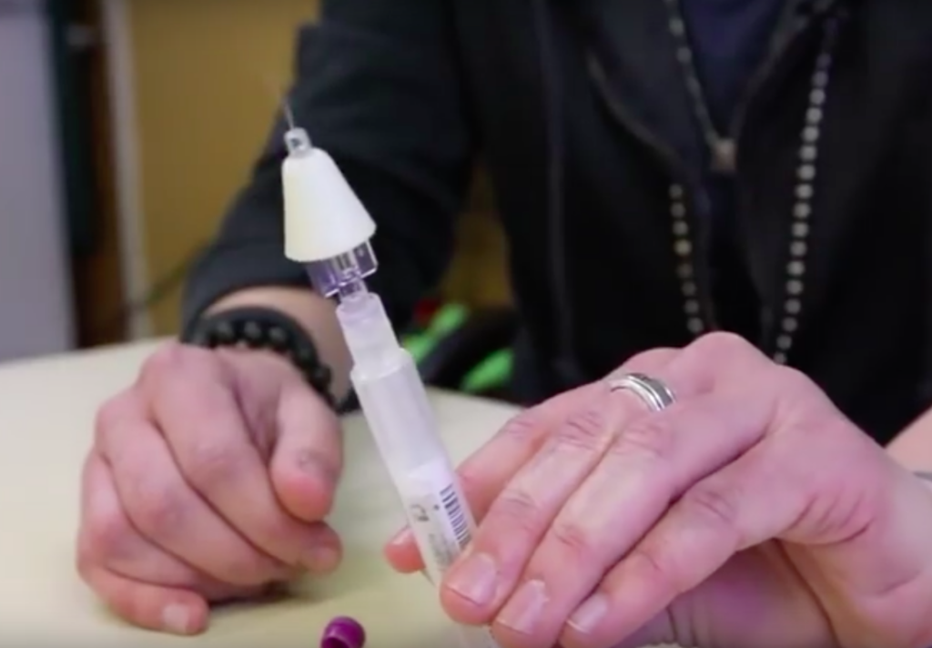 person holding naloxone applicator