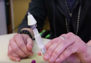 person holding naloxone applicator