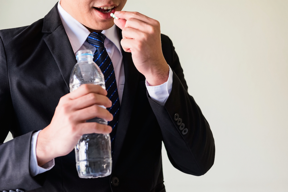 businessman taking a pill