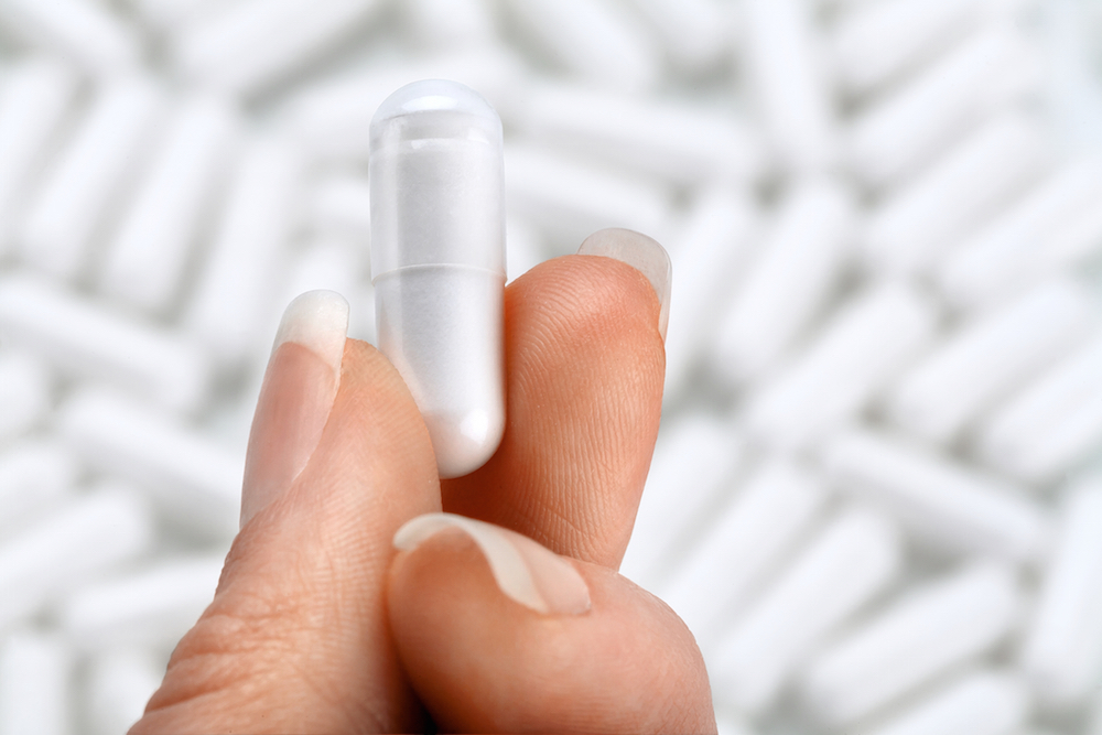 close up of hand holding a pill