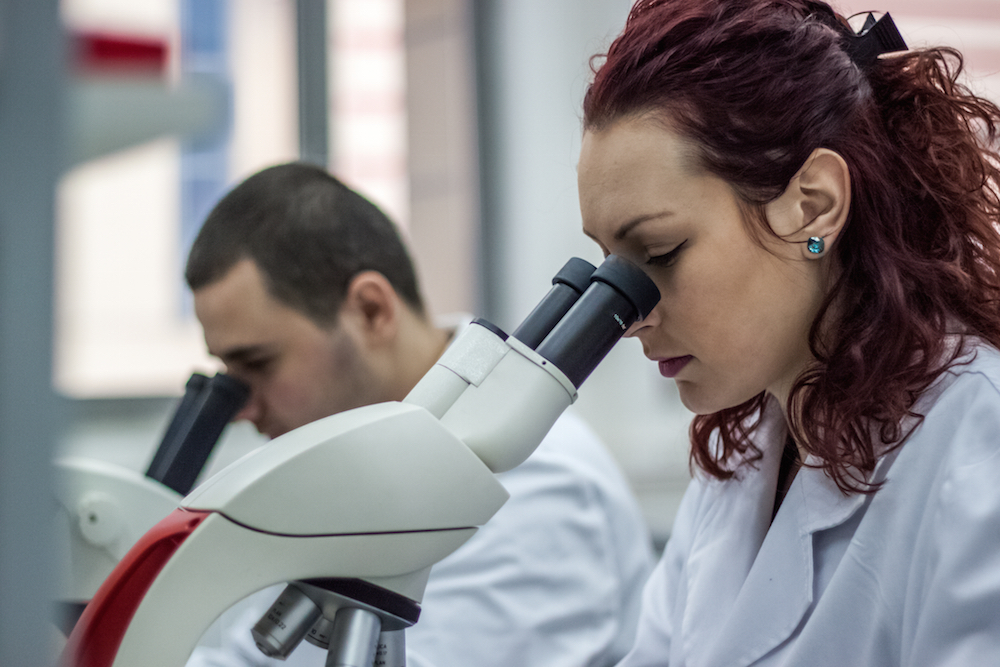 scientific researchers looking through microscopes