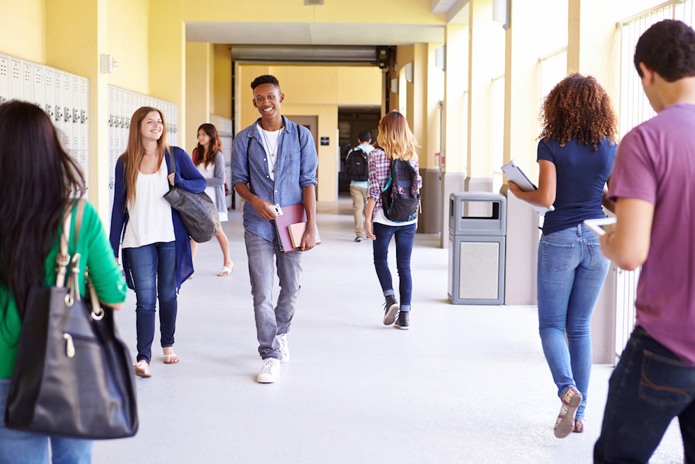 group of high school students walking down hallway