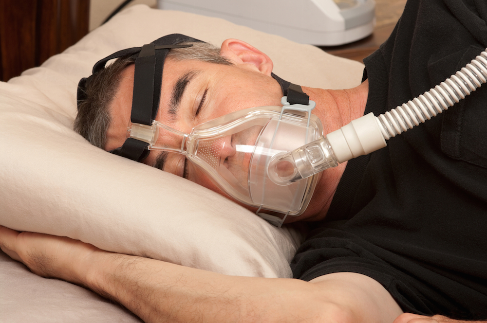 man sleeping with CPAP machine