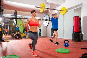 Man and woman lifting weights in a gym