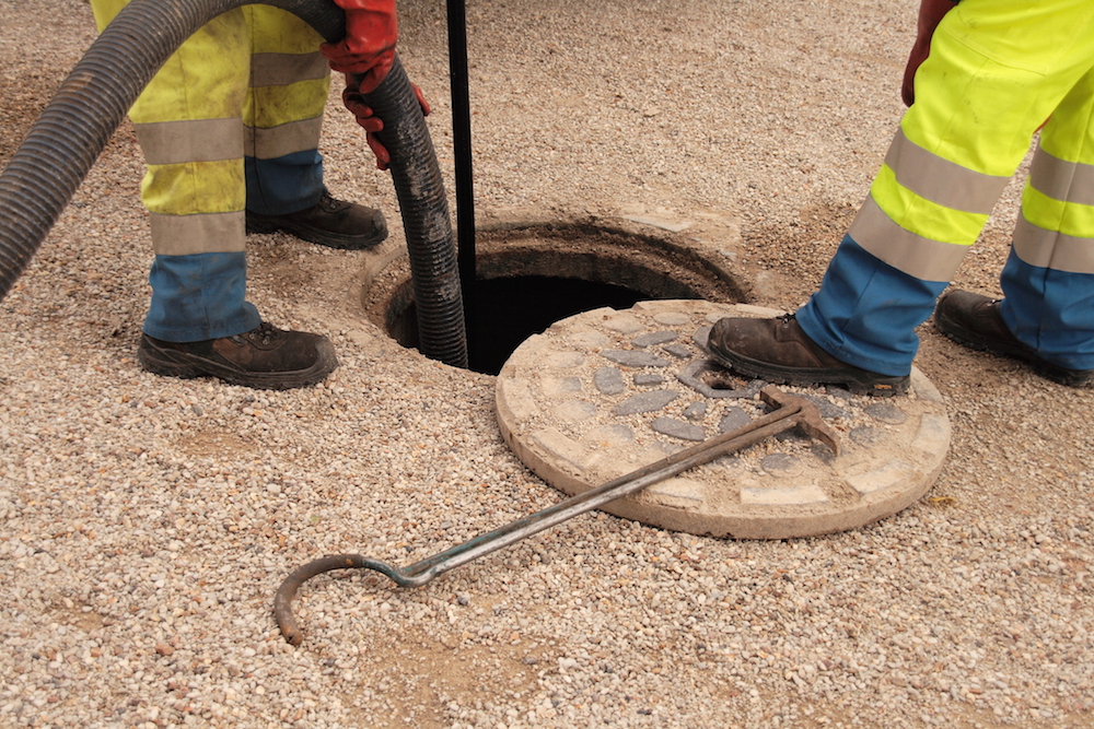 workers cleaning out a sewage pipe