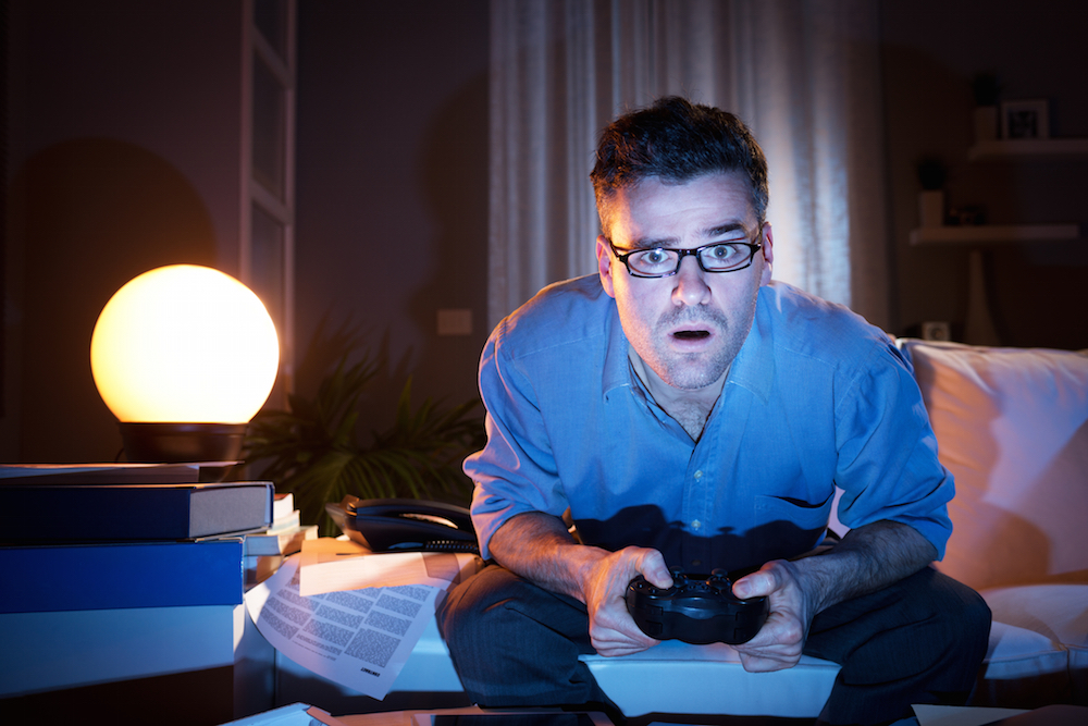 man playing video games at night