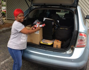 Margaret Bordeaux gets supplies from the trunk of a car.