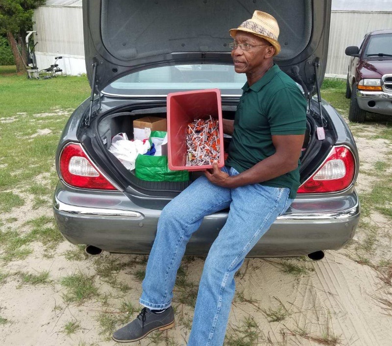 Jessie Garner sitting on car trunk full of items to help people addicted to opioids