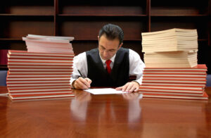 seated lawyer surrounded by stacks of documents
