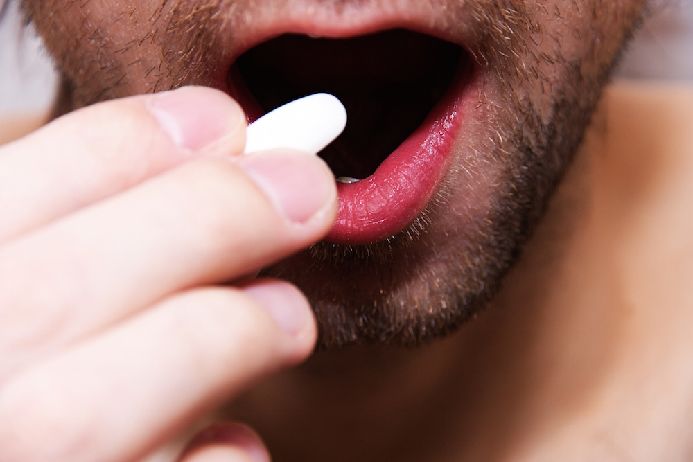 close-up of man taking pills