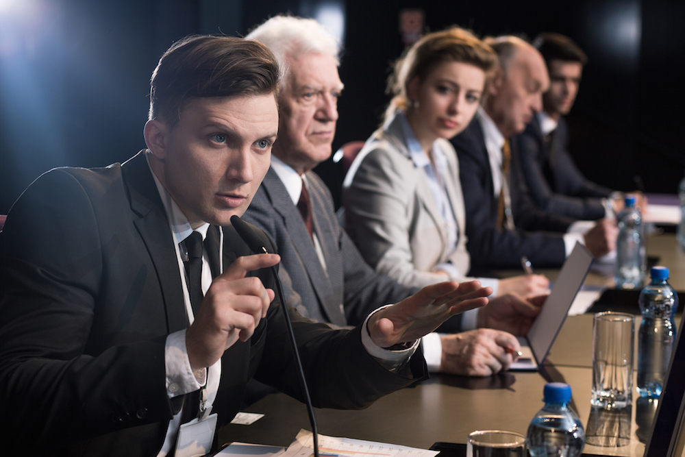 Young businessman giving press conference with microphone