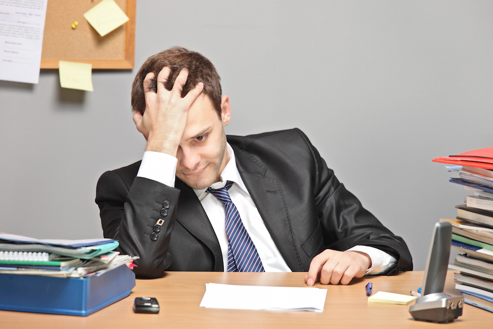 man sitting sadly at his desk