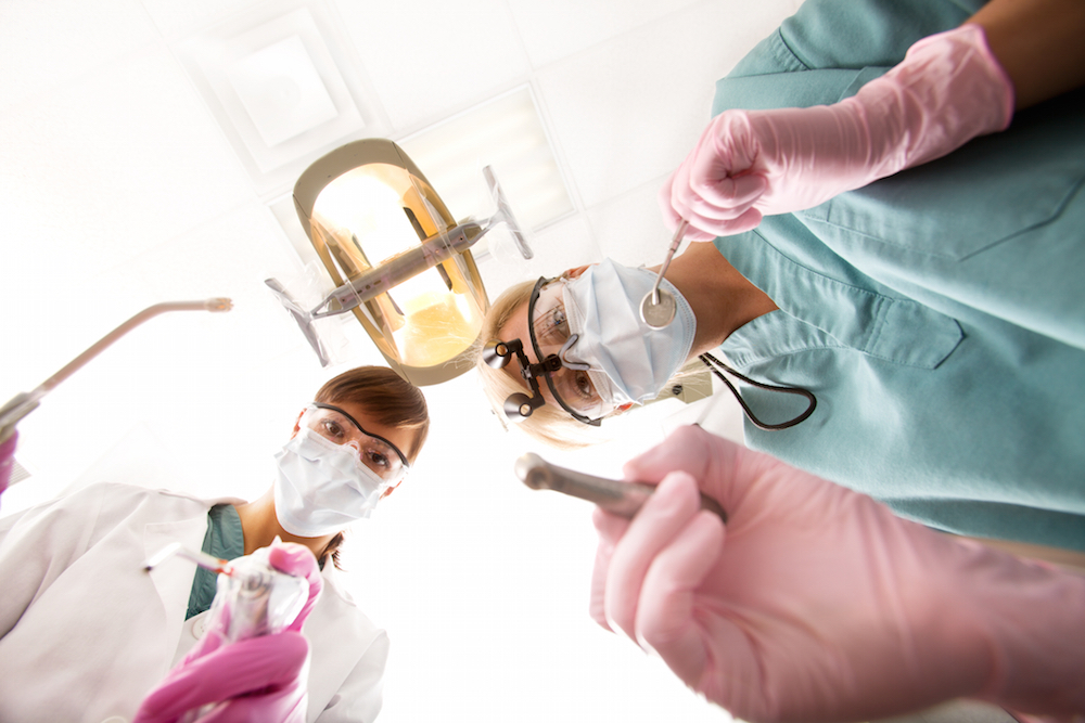 dentist moving in to perform dental procedure.