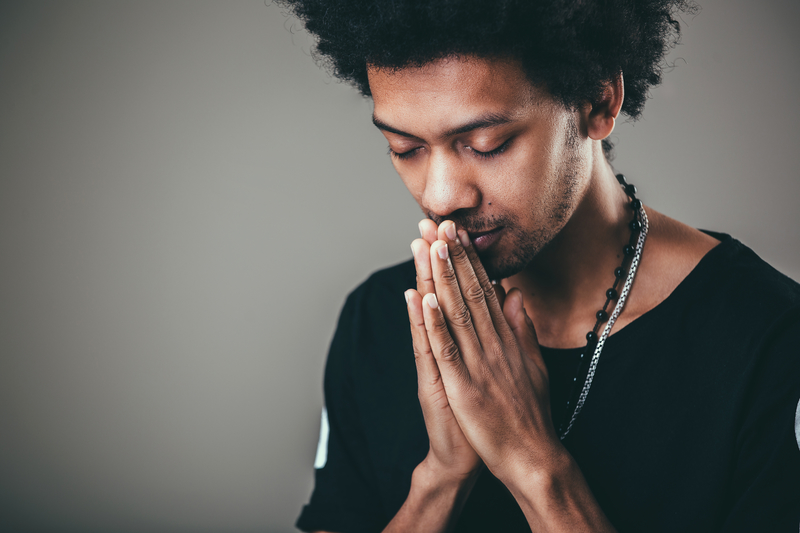Black man praying for forgiveness