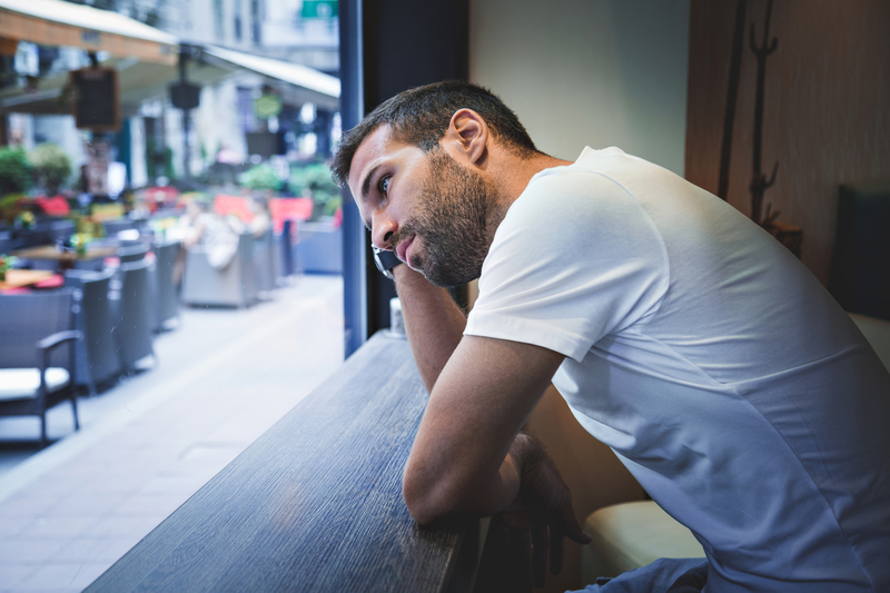 man thinking at window sill