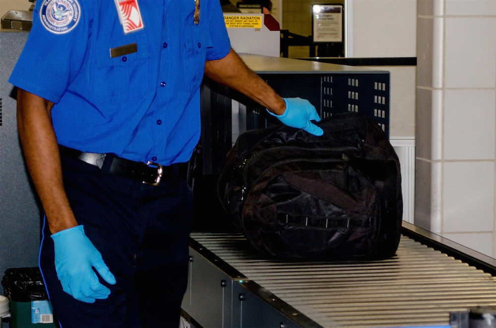 TSA agent inspecting a bag.