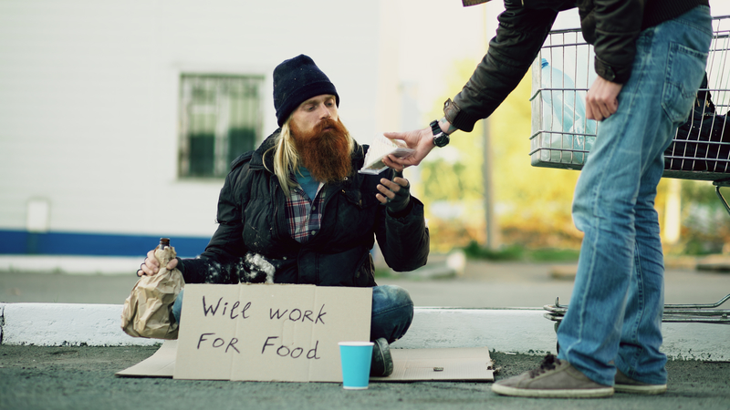 giving money to a bearded homeless man