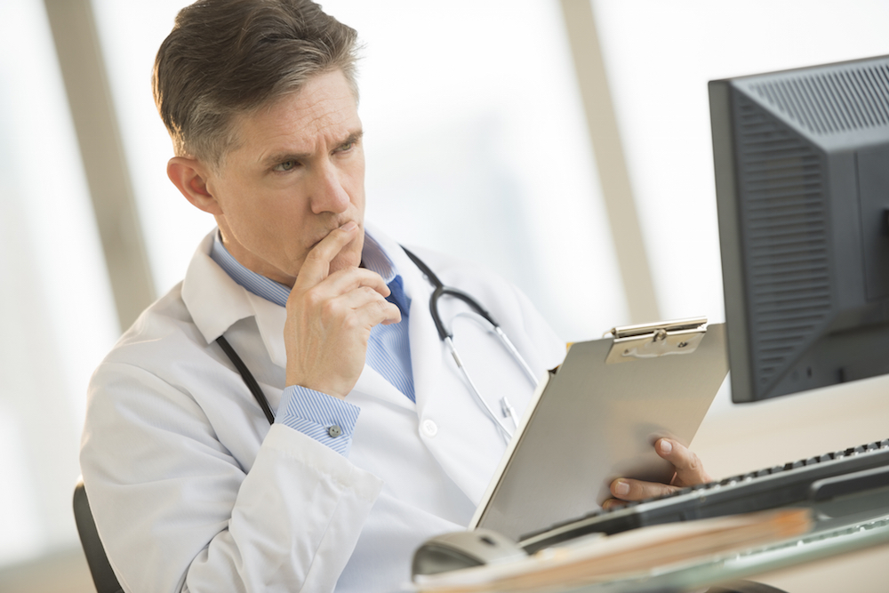 New York doctor using the prescription monitoring system on his computer